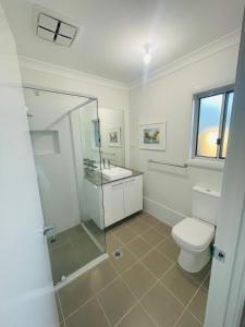 a bathroom with a toilet and a shower and a sink at Guest house Que Sera in Cooranbong +10 photos
