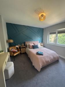 a bedroom with a large bed and a blue wall at House Aurora in Edinburgh