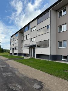 a large apartment building with a grassy field in front at Taagepera Guest Apartment in Taagepera