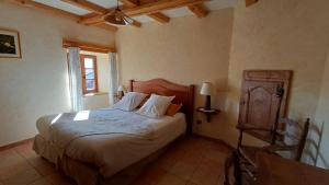 a bedroom with a bed with white sheets and a window at La Maison de Julia in Blanzac