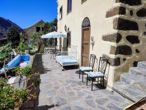 a patio with chairs and an umbrella next to a building at Middle Earth in El Paso