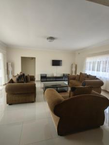 a living room with couches and a flat screen tv at 55 On Paisley in Bulawayo