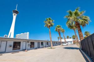 a building with palm trees and a tower at OYO Oasis Motel Las Vegas I-15 in Las Vegas