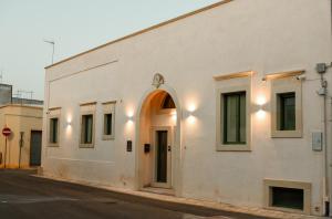 a white building with an archway on a street at Assunta Affittacamere in Vitigliano