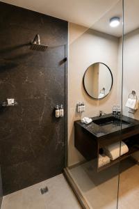 a bathroom with a shower with a sink and a mirror at Wyndham Garden Durango in Durango