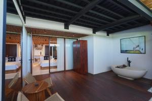 ein Badezimmer mit Badewanne und ein Zimmer mit einem Schlafzimmer in der Unterkunft Casa Sol Hotel in Canggu