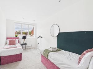 a bedroom with two beds and a mirror on the wall at Luxury Two Bed | Sleeps 6 | 5 beds in Brent Station
