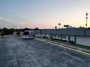 a parking lot with a car parked in front of a building at Texas Inn & Suites in Denton +3 photos