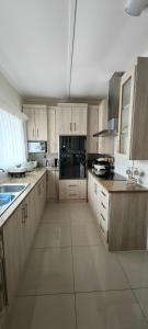 a large kitchen with wooden cabinets and black appliances at 55 On Paisley in Bulawayo