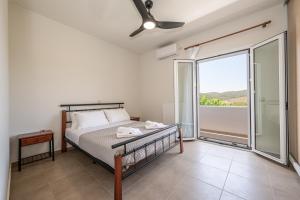 a bedroom with a bed and a large window at CASA di FLORI in Epáno Flória +25 photos