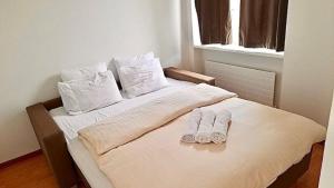 a bed with two pairs of slippers sitting on it at 2 Room Center Zurich Flats with Balcony - HildaB in Zurich