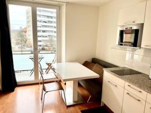 a small kitchen with a white table and a window at 2 Room Center Zurich Flats with Balcony - HildaB in Zurich