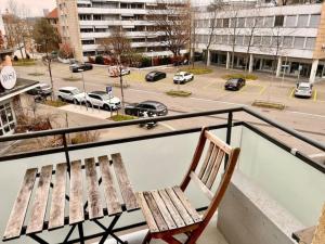 a wooden bench sitting on a balcony overlooking a parking lot at 2 Room Center Zurich Flats with Balcony - HildaB in Zurich