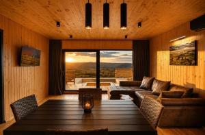 a living room with a couch and a table at Sunset Hill Chalet Sighișoara in Sighişoara