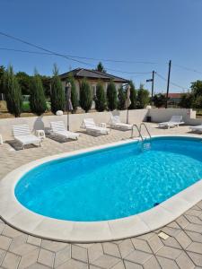 a swimming pool in a patio with lounge chairs at Pećinska Vila in Kragujevac