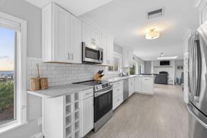 a kitchen with white cabinets and a large window at Gulls Nest in Gloucester