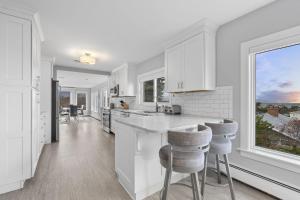 a kitchen with white cabinets and a large window at Gulls Nest in Gloucester +19 photos