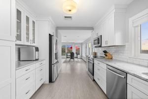 a white kitchen with white cabinets and appliances at Gulls Nest in Gloucester