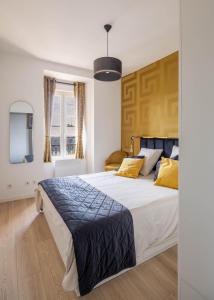 a bedroom with a large bed with yellow pillows at La Bulle Dorée in Épernay