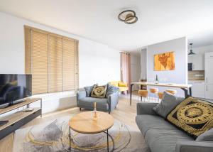 a living room with a couch and a table at La Bulle Dorée in Épernay