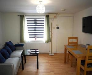 a living room with a couch and a table and a window at Ground Floor Flat 1 Seven Cambrian square in Newtown