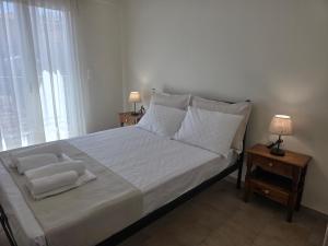 a bedroom with a large bed with white sheets and pillows at Diogenes Apartments in Samos