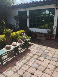 two hats sitting on a picnic table in front of a house at Alojamiento Rural San Antonio in Ubaté +7 photos