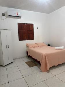 a bedroom with a bed and a cabinet in it at Casa Fronteira in Oiapoque