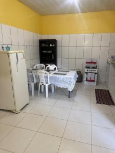 a kitchen with a table and a refrigerator at Casa Fronteira in Oiapoque