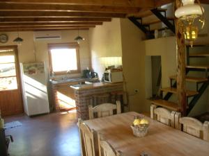 a kitchen and dining room with a wooden table and a kitchen at Cabañas "Lola Mora" in Tandil