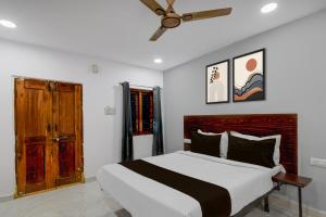 a bedroom with a large bed and a ceiling fan at Super Hotel O iva Holiday inn in Maula Ali +21 photos