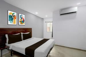 a bedroom with a large bed and two paintings on the wall at Super Hotel O iva Holiday inn in Maula Ali
