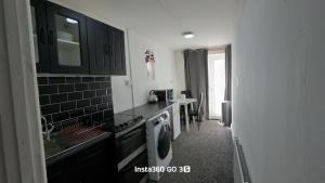 a kitchen with a sink and a washing machine at Abysplace SM in Kenton