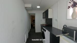 a kitchen with white walls and a black counter top at Abysplace SM in Kenton +2 photos