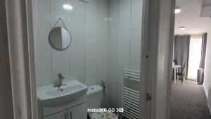 a white bathroom with a sink and a mirror at Abysplace SM in Kenton