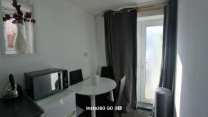 a room with a table and a tv and a window at Abysplace SM in Kenton