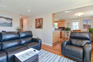 a living room with two leather couches and a kitchen at Ryal Side Hideaway Cove in Beverly