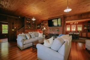 a living room with white couches and a flat screen tv at Tidebend in Gloucester