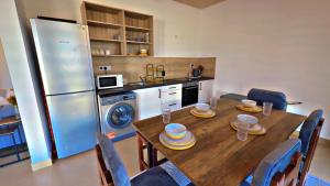 a kitchen with a wooden table and a refrigerator at Two Bedroom Moyoni Apartment in Mchamba Wima