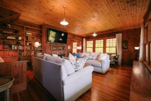 a living room with two white couches and a tv at Tidebend in Gloucester