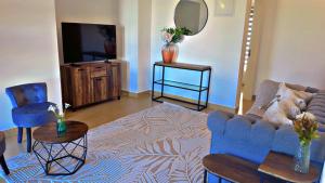 a living room with a blue couch and a tv at Two Bedroom Moyoni Apartment in Mchamba Wima