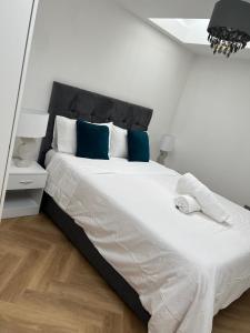 a bedroom with a large white bed with blue pillows at Modern peaceful property Breakfast included in Blean
