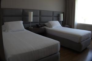 a hotel room with two beds and a window at Hotel Estelar El Cable in Manizales