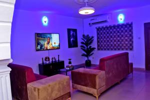 a living room with purple walls and couches at Hilltop Apartments in Mosan