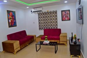 a living room with two red couches and a table at Hilltop Apartments in Mosan