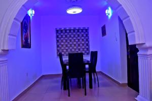 a dining room with purple lighting and a table and chairs at Hilltop Apartments in Mosan