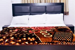 a bed with a blue headboard and a blanket at Hilltop Apartments in Mosan