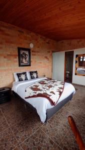 a bedroom with a large bed in a brick wall at Alojamiento temático Rancho Texas in La Mesa
