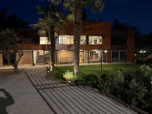 a building with palm trees in front of it at Spa Pirque & Hotel in Pirque