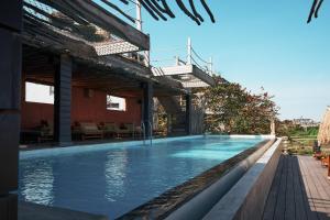 ein Schwimmbad neben einem Gebäude in der Unterkunft Casa Sol Hotel in Canggu